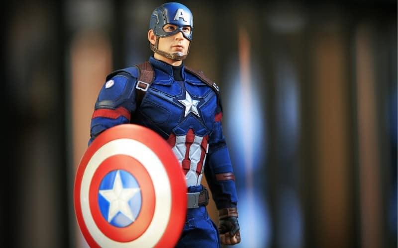 Captain America in his suit is holding the shield