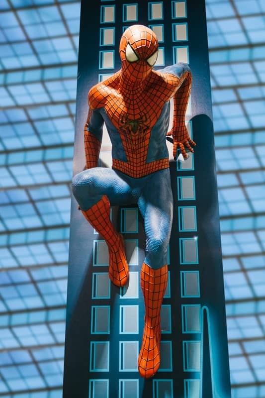 Spiderman holding his body along a building