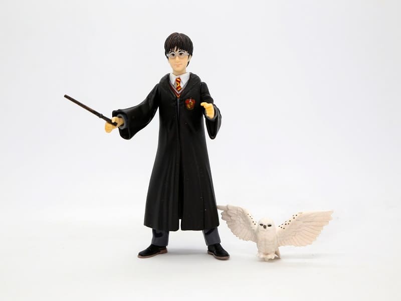 Harry Potter with his white owl Hedwig. Harry dressed in his Hogwarts School of Witchcraft and Wizardry uniform and his wand in hand