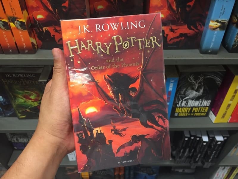 a hand holding a book of Harry Potter and The Order of the Phoenix