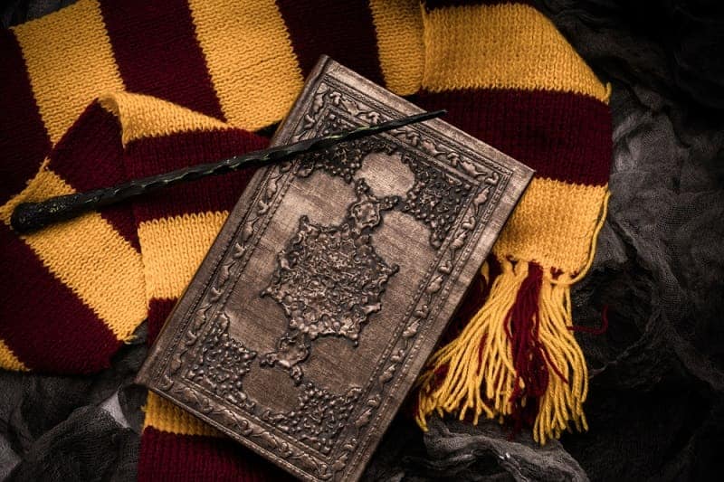 scarf, magic wand, book of magic on dark gray rag background