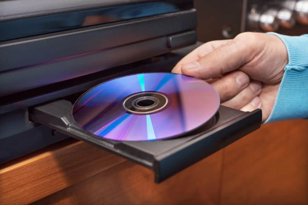 a person inserts dvd into video player